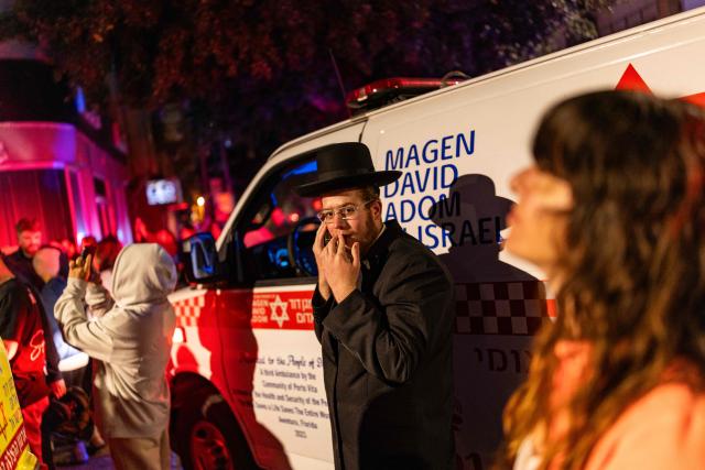 People gather at the site where an apartment was damaged by a missile strike, in the outskirts of Tel Aviv, Israel on March 18, 2026. (Photo by Ilia YEFIMOVICH / AFP) / 