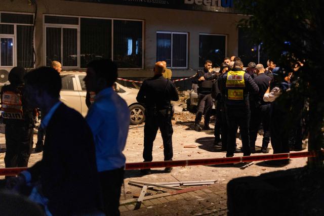 Police and first responders work at a scene where an apartment was damaged by a missile strike, in the outskirts of Tel Aviv, Israel on March 18, 2026. (Photo by Ilia YEFIMOVICH / AFP) / 