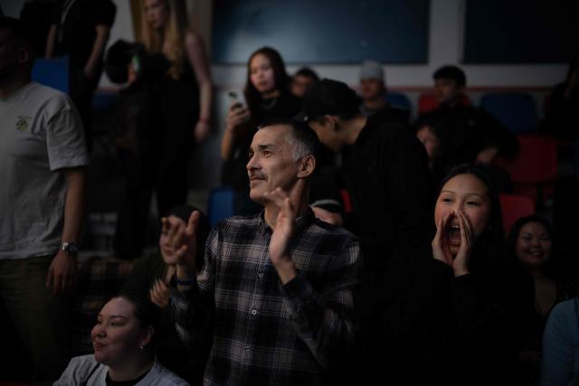Members of the crowd applaud and shout their support for the Greenlandic fighters during a boxing match in Nuuk, Greenland, on February 28, 2026. Greenland has one of the highest suicide rates in the world, especially among teenagers and young adults. Psychiatric care is uneven, and many youths must leave their families to study in Nuuk. In the capital, many turn to boxing as a way to channel their pain. (Photo by Florent VERGNES / AFP)