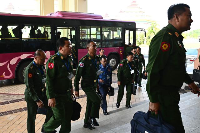 Military officers, who serve as members of Myanmar's parliament, arrive for a session of the Amyotha Hluttaw, Upper House of Parliament of Myanmar, in Naypyidaw on March 18, 2026. (Photo by Sai Aung MAIN / AFP)