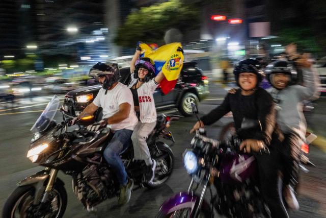 TOPSHOT - Venezuelan fans celebrate their national baseball team's victory in the final of the 2026 World Baseball Classic against the United States team, in Caracas on March 17, 2026. Venezuela, where baseball is the national sport, capped off its dream tournament by defeating the favorite, the United States, on home soil, amid tense relations between the two governments following the capture of President Nicolás Maduro by U.S. forces in January. (Photo by Juan BARRETO / AFP)