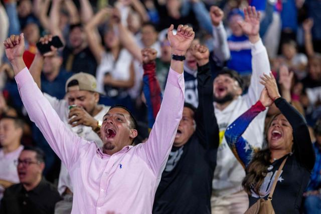 Venezuelan fans celebrate their national baseball team's victory in the final of the 2026 World Baseball Classic against the United States team, in Caracas on March 17, 2026. Venezuela, where baseball is the national sport, capped off its dream tournament by defeating the favorite, the United States, on home soil, amid tense relations between the two governments following the capture of President Nicolás Maduro by U.S. forces in January. (Photo by Juan BARRETO / AFP)