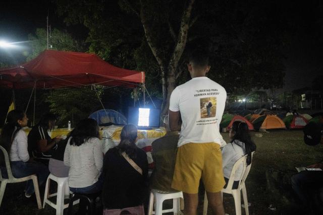 Relatives of political prisoners watch on a television screen the final of the 2026 World Baseball Classic between Venezuela and the United States, in front of Rodeo I prison in Guatire, Venezuela on March 17, 2026. Venezuela, where baseball is the national sport, capped off its dream tournament by defeating the favorite, the United States, on home soil, amid tense relations between the two governments following the capture of President Nicolás Maduro by U.S. forces in January. (Photo by Maryorin Mendez / AFP)