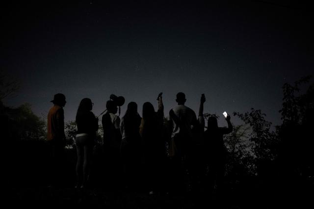 Relatives of political prisoners listen to the messages of the prisoners nearby of Rodeo I prison in Guatire, Venezuela on March 17, 2026. Venezuelan authorities granted amnesty to 379 political prisoners on February 20, 2026 after a new mass amnesty law was enacted following the ouster of former leader Nicolas Maduro. (Photo by Maryorin Mendez / AFP)
