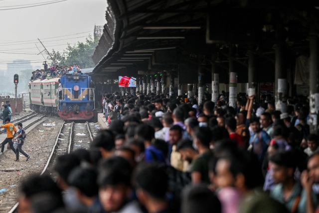 Bangladeshis wait to board a train at a railway station in Tongi on March 18, 2026 as they return to their hometowns ahead of the Muslim festival of Eid al-Fitr. (Photo by MUNIR UZ ZAMAN / AFP)