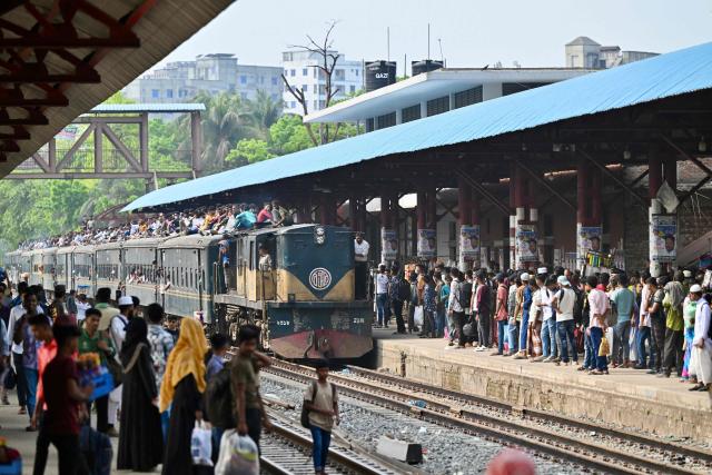 Bangladeshis wait to board a train at a railway station in Tongi on March 18, 2026 as they return to their hometowns ahead of the Muslim festival of Eid al-Fitr. (Photo by MUNIR UZ ZAMAN / AFP)