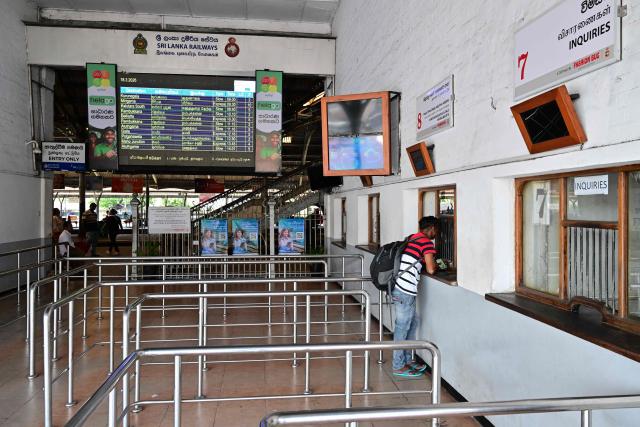 A man stands in front of a ticket counter at a deserted railway station in Colombo on March 18, 2026. Sri Lanka announced a shorter work week to conserve its scarce fuel reserves as it prepares for a prolonged war in the Middle East, officials said on March 16. (Photo by Ishara S. KODIKARA / AFP)