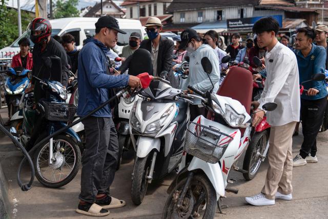 Motorists queue up at a Star Oil petrol station in Luang Prabang on March 16, 2026, following import disruptions caused by the Middle East war. (Photo by AFP)