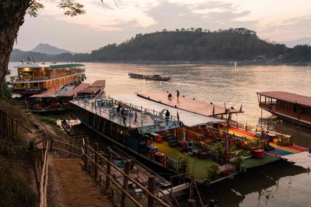 Sunset cruise boats are moored along the Mekong riverbank in Luang Prabang on March 16, 2026. (Photo by AFP)