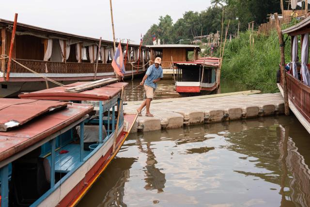 A man pulls his boat to the Mekong riverbank in Luang Prabang on March 16, 2026. (Photo by AFP)