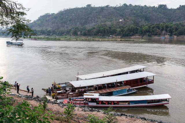 Tourists get on boats for their sunset cruise on the Mekong river in Luang Prabang on March 16, 2026. (Photo by AFP)