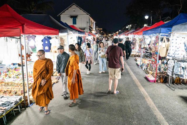 Visitors walk through a night market in Luang Prabang on March 16, 2026. (Photo by AFP)