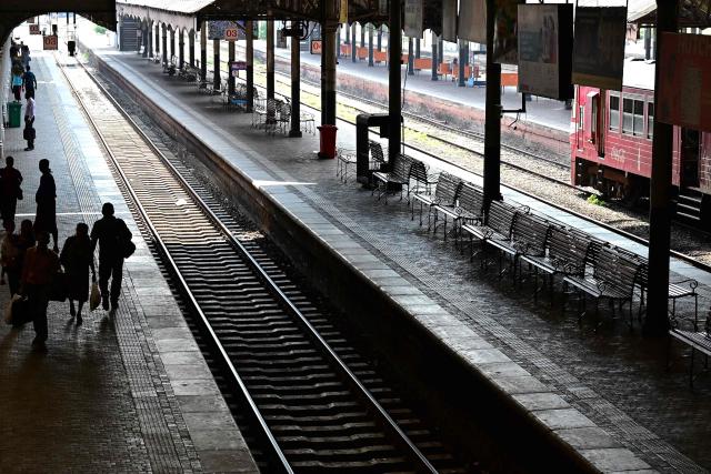 People walk at the deserted Fort Railway Station in Colombo on March 18, 2026. Sri Lanka announced a shorter work week to conserve its scarce fuel reserves as it prepares for a prolonged war in the Middle East, officials said on March 16. (Photo by Ishara S. KODIKARA / AFP)