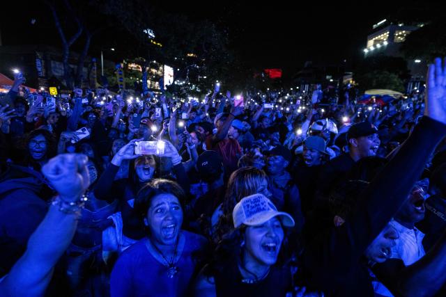 Venezuela fans celebrate their national baseball team's victory in the final of the 2026 World Baseball Classic against the United States team, in Caracas on March 17, 2026. Venezuela, where baseball is the national sport, capped off its dream tournament by defeating the favorite, the United States, on home soil, amid tense relations between the two governments following the capture of President Nicolas Maduro by US forces in January. (Photo by Juan BARRETO / AFP)
