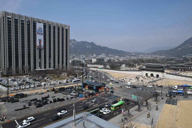This picture taken on March 16, 2026 shows workers setting up the stage (C, bottom) for a comeback concert of K-pop boy group BTS in front of Gwanghwamun Gate (R), the main gate of Gyeongbokgung Palace, in Seoul. More than a quarter of a million fans are expected to throng central Seoul on March 21 for BTS's open-air gig, the first performance in almost four years by the boy band seen as the biggest in the world. (Photo by Jung Yeon-je / AFP)