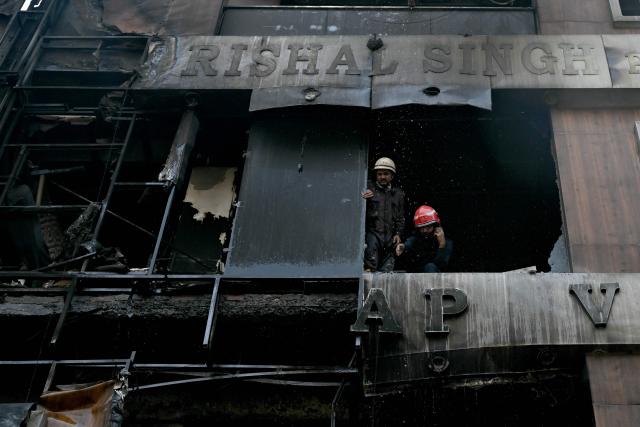 Firefighters douse flames after a fire broke out at a residential building in New Delhi on March 18, 2026. (Photo by Arun SANKAR / AFP)