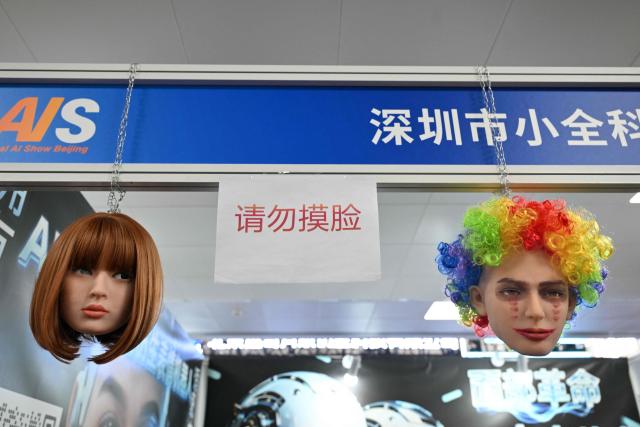 Humanoid robotic heads that mimic human expressions from Shenzhen Xiaoquan Technology are displayed during the International AI Application and Robotics Innovation Exhibition in Beijing on March 18, 2026. (Photo by ADEK BERRY / AFP)