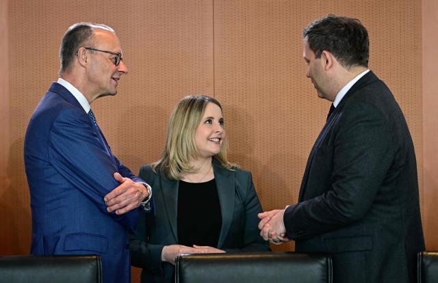 German Chancellor Friedrich Merz (L) and German Finance Minister and Vice Chancellor Lars Klingbeil (R) greet German Minister for Housing, Urban Development and Building Verena Hubertz prior the start of the weekly cabinet meeting, on March 18, 2026 at the Chancellery in Berlin. (Photo by Tobias SCHWARZ / AFP)