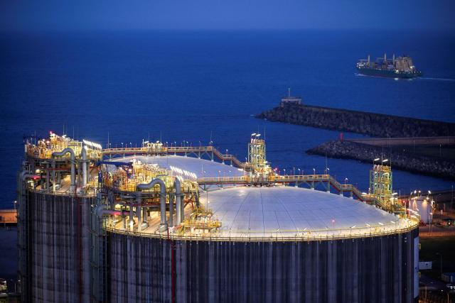 A picture taken at sunset on March 17, 2026 shows a general view of the Musel E-Hub regasification terminal in the Spanish city of Gijon. The US-Israeli war on Iran has expanded across the Gulf and beyond, upending global energy markets and trade, and virtually halting traffic in the Strait of Hormuz, through which a fifth of the world's crude oil travels. (Photo by ANDER GILLENEA / AFP)