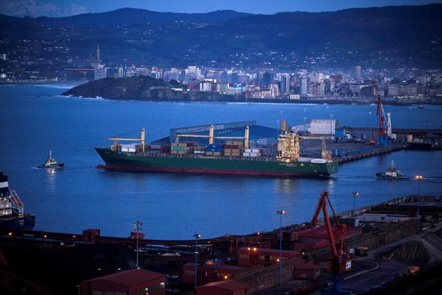 A picture taken at sunset on March 17, 2026 shows tugboats assisting the vessel MSC Salina III, a container ship sailing under flag of Portugal, as she leaves the Port of the Spanish city of Gijon. The US-Israeli war on Iran has expanded across the Gulf and beyond, upending global energy markets and trade, and virtually halting traffic in the Strait of Hormuz, through which a fifth of the world's crude oil travels. (Photo by ANDER GILLENEA / AFP)