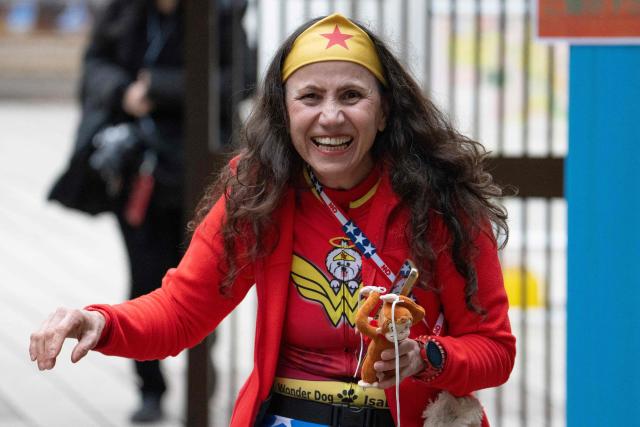 A woman holds a stuffed monkey toy while visiting the zoo to see a seven month-old male Japanese macaque monkey named Punch at Ichikawa City Zoo and Botanical Gardens in Ichikawa, Chiba Prefecture on March 18, 2026. (Photo by Yuichi YAMAZAKI / AFP)
