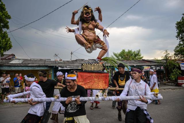 TOPSHOT - Hindu devotees carry an Ogoh-ogoh, a statue symbolising an evil spirit, during a parade on the eve of Nyepi in Surabaya on March 18, 2026. Hindus in Indonesia, the world's largest Muslim-populated nation, will celebrate the "Day of Silence" locally known as Nyepi which marks the new year in the Balinese Hindu calendar on March 19. (Photo by JUNI KRISWANTO / AFP)