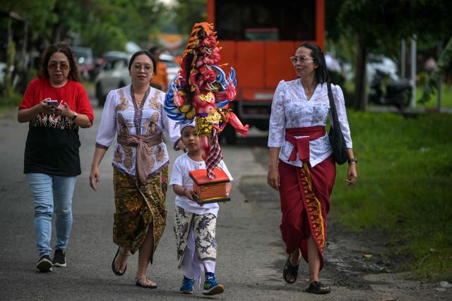 A child carries an Ogoh-ogoh, a statue symbolising an evil spirit, during a parade on the eve of Nyepi in Surabaya on March 18, 2026. Hindus in Indonesia, the world's largest Muslim-populated nation, will celebrate the "Day of Silence" locally known as Nyepi which marks the new year in the Balinese Hindu calendar on March 19. (Photo by JUNI KRISWANTO / AFP)