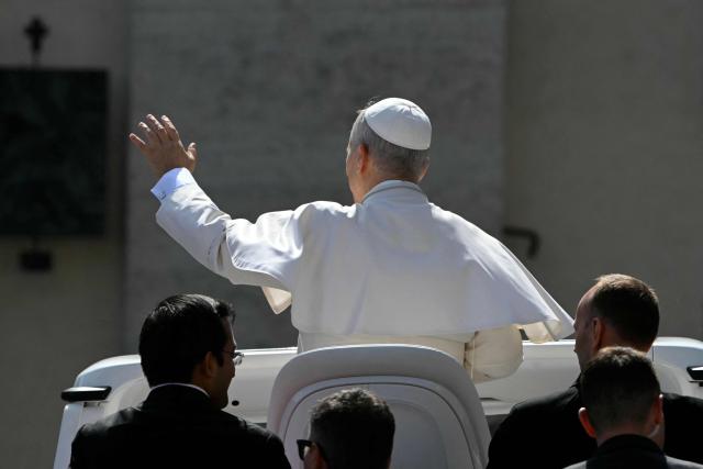 Pope Leo XIV waves to the crowd at the end of the weekly general audience at St Peter's Square in The Vatican on March 18, 2026. (Photo by Andreas SOLARO / AFP)