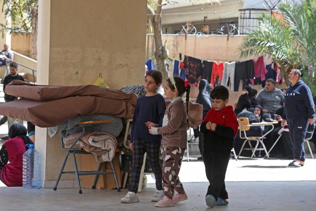 Displaced children from southern Lebanon, walk at the courtyard of a school turned into a shelter in the southern coastal city of Sidon on March 18, 2026. Lebanon was drawn into the Middle East war on March 2 when militant group Hezbollah launched rockets into Israel to avenge the killing of Iran's supreme leader Ayatollah Ali Khamenei. Israel responded with intense strikes on multiple regions around the country and by launching ground operations in the south. (Photo by MAHMOUD ZAYYAT / AFP)