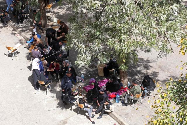 Displaced families from southern Lebanon, sit at the courtyard of a school turned into a shelter in the southern coastal city of Sidon on March 18, 2026. Lebanon was drawn into the Middle East war on March 2 when militant group Hezbollah launched rockets into Israel to avenge the killing of Iran's supreme leader Ayatollah Ali Khamenei. Israel responded with intense strikes on multiple regions around the country and by launching ground operations in the south. (Photo by MAHMOUD ZAYYAT / AFP)