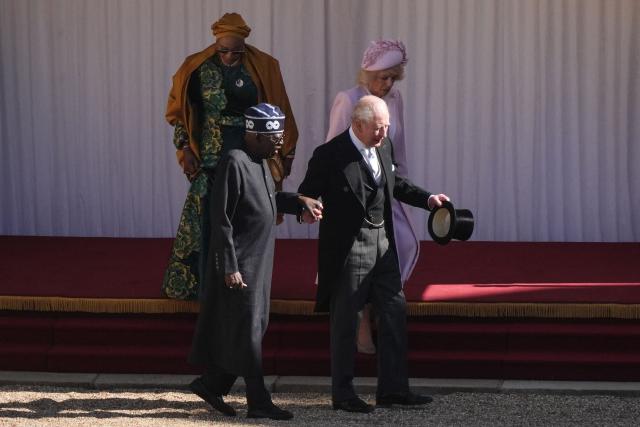 Britain's King Charles III holds hands with Nigeria's President Bola Tinubu as they leave with Britain's Queen Camilla and Nigeria's First Lady Oluremi Tinubu following a ceremonial welcome in the Quadrangle at Windsor Castle, in Windsor, on March 18, 2026, on the first day of a two-day State Visit to the United Kingdom by Nigeria's President. (Photo by Jonathan Brady / POOL / AFP)