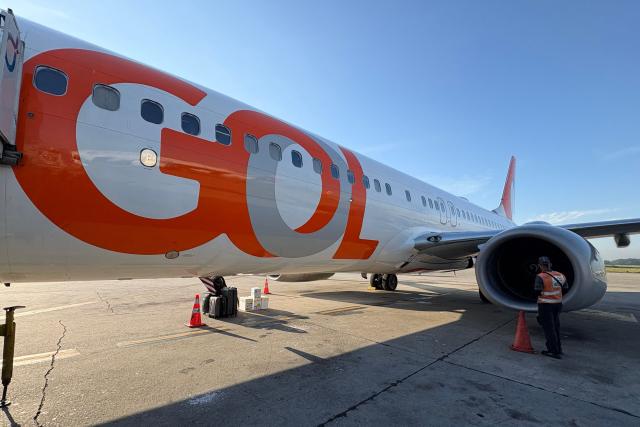 A worker checks an engine of a GOL Airlines plane at Guarulhos International Airport in Sao Paulo, Brazil, on March 18, 2026. (Photo by Pablo PORCIUNCULA / AFP)