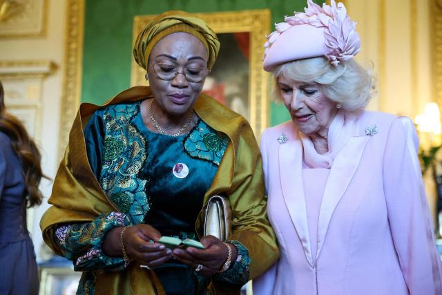 Nigeria's First Lady Oluremi Tinubu (L) and Britain's Queen Camilla look at a Manuscript of poems by Nigerian-born British poet Ben Okri, as part of a special exhibition of Royal Collection items, relating to Nigeria, in the Green Drawing Room at Windsor Castle , in Windsor, on March 18, 2026, on the first day of a two-day State Visit to the United Kingdom by Nigeria's President. (Photo by Hannah McKay / POOL / AFP)