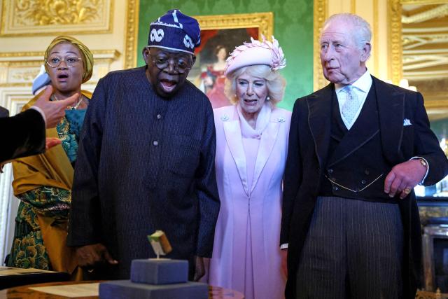 Nigeria's President Bola Tinubu (2L), his wife Oluremi Tinubu (L), along with Britain's Queen Camilla and Britain's King Charles III (R) reacts as they are shown a Manuscript of poems by Nigerian-born British poet Ben Okri, aspart of a special exhibition of Royal Collection items, relating to Nigeria, in the Green Drawing Room at Windsor Castle , in Windsor, on March 18, 2026, on the first day of a two-day State Visit to the United Kingdom by Nigeria's President. (Photo by Hannah McKay / POOL / AFP)