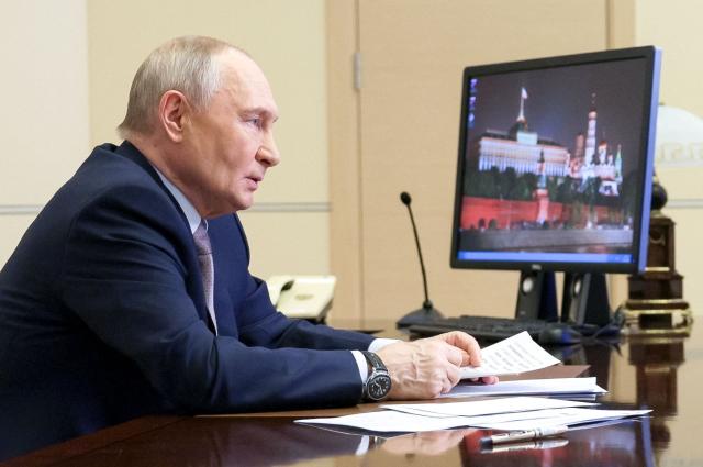 In this pool photograph distributed by the Russian state agency Sputnik, Russia's President Vladimir Putin chairs a meeting with members of the government via videoconference at the Novo-Ogaryovo residence outside Moscow on March 18, 2026. (Photo by Gavriil Grigorov / POOL / AFP)