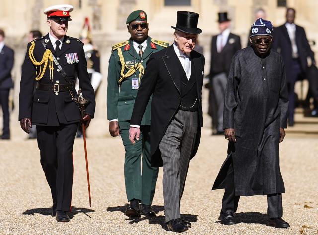 Britain's King Charles III walks with Nigeria's President Bola Tinubu during a ceremonial welcome in the Quadrangle at Windsor Castle, in Windsor, on March 18, 2026, on the first day of a two-day State Visit to the United Kingdom by Nigeria's President. (Photo by Aaron Chown / POOL / AFP)