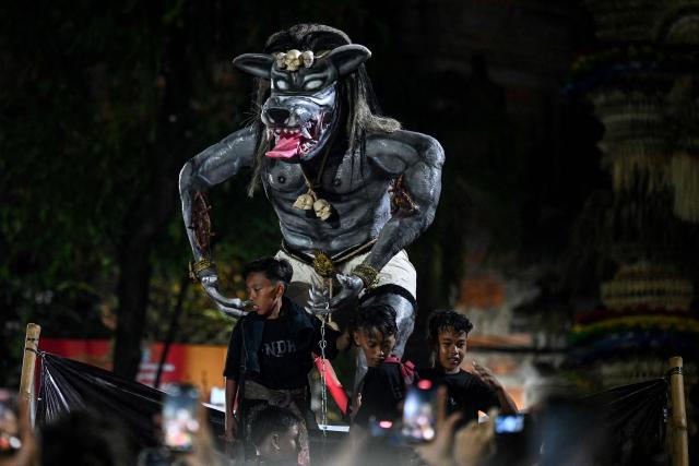 Hindu devotees carry effigies called 'ogoh-ogoh', symbolising an evil spirit, during a parade on the eve of Nyepi, the Day of Silence that marks the New Year in the Balinese Hindu calendar, in Denpasar, Bali on March 18, 2026. (Photo by Sonny TUMBELAKA / AFP)