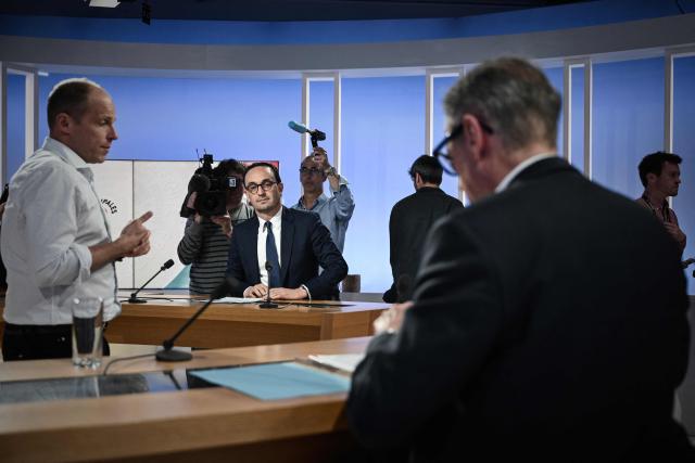 Thomas Cazenave (L), Renaissance-Horizons candidate for the Bordeaux mayoral election, sits at the debate desk in front of incumbent mayor Pierre Hurmic (R) on the set of France 3 television in Bordeaux, south-western France, on March 18, 2026, before the second round of the 2026 French municipal elections on March 22. (Photo by Philippe LOPEZ / AFP)