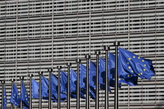This photograph shows European flags fluttering outside the EU Commission headquarters in Brussels on March 18, 2026. (Photo by Nicolas TUCAT / AFP)
