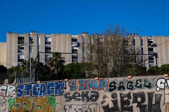 This photograph taken from the highway shows a wall with graffitis surrrounding a building at the Castellane neighbourhood in northern Marseille, southern France on March 17, 2026. (Photo by Elodie CLEMENT / AFP)