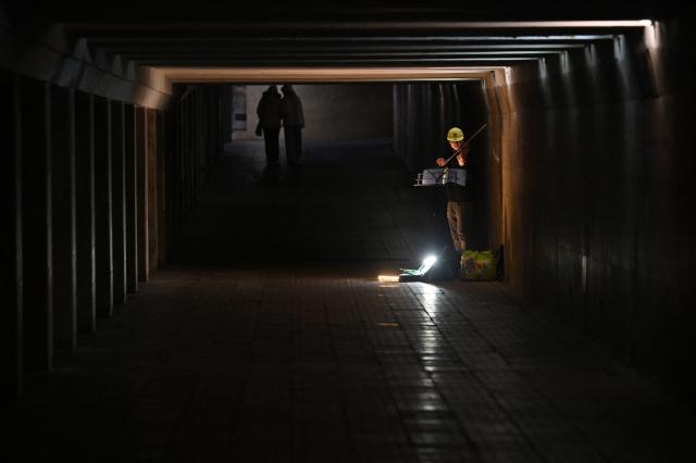 A boy plays violin in an underground pedestrian way in the center of Kyiv, on March 18, 2026, amid the Russian invasion in Ukraine. (Photo by Sergei SUPINSKY / AFP)