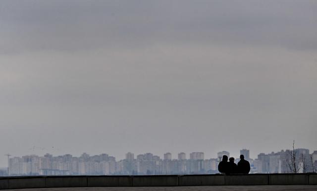 People look at the Kyiv view on a cold spring day in Ukrainian capital of Kyiv on March 18, 2026, amid the Russian invasion in Ukraine. (Photo by Sergei SUPINSKY / AFP)