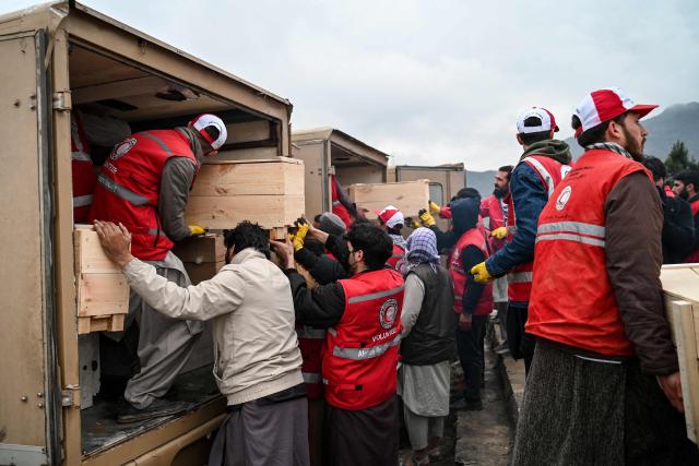 Afghan Red Crescent Society volunteers load coffins into ambulances after offering funeral prayers for victims of a Pakistani air strike on a drug rehabilitation centre, during a mass burial ceremony at the Badam Bagh Hilltop in Kabul on March 18, 2026. The Taliban authorities have said that around 400 people were killed and more than 200 wounded on March 16 night, in the deadliest attack yet in the recent upsurge in violence between the two neighbours. (Photo by Wakil KOHSAR / AFP)
