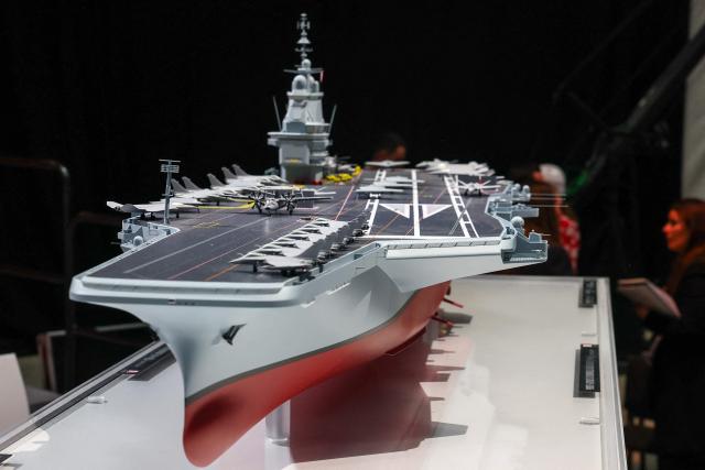 This photograph shows the model of a ship named "France Libre" as French President visits the construction site of Naval Group Nantes-Indret, where the next generation French aircraft carrier is under construction, in Indret, western France, on March 18, 2026. The French president unveiled the name of France's next aircraft carrier: "France libre", as the country looks to reinforce its status as a major maritime power. Once completed, the new nuclear-powered flagship, which is set to replace the country's sole aircraft carrier, the Charles de Gaulle, will be the largest warship ever built in Europe. (Photo by Gonzalo Fuentes / POOL / AFP)