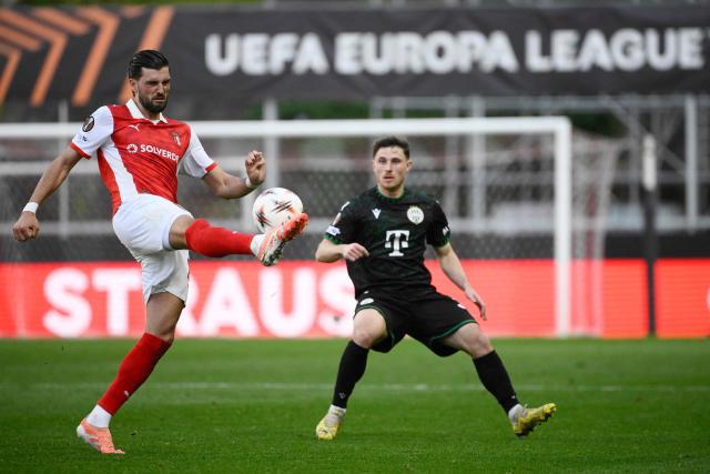 Sporting Braga's Austrian midfielder #27 Florian Grillitsch (L) kicks the ball next to Ferencvaros' Israeli midfielder #36 Gavriel Kanichowsky during the UEFA Europa League last 16 second leg football match between SC Braga and Ferencvaros at Municipal stadium of Braga on March 18, 2026. (Photo by Miguel RIOPA / AFP)
