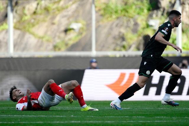 Sporting Braga's Uruguayan midfielder #10 Rodrigo Zalazar (L) reacts after falling down to the ground next to Ferencvaros' Argentinian defender #04 Mariano Gomez during the UEFA Europa League last 16 second leg football match between SC Braga and Ferencvaros at Municipal stadium of Braga on March 18, 2026. (Photo by Miguel RIOPA / AFP)