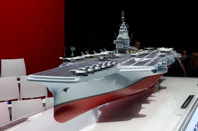 This photograph shows the model of a ship named "France Libre" as French President visits the construction site of Naval Group Nantes-Indret, where the next generation French aircraft carrier is under construction, in Indret, western France, on March 18, 2026. The French president unveiled the name of France's next aircraft carrier: "France libre", as the country looks to reinforce its status as a major maritime power. Once completed, the new nuclear-powered flagship, which is set to replace the country's sole aircraft carrier, the Charles de Gaulle, will be the largest warship ever built in Europe. (Photo by Gonzalo Fuentes / POOL / AFP)