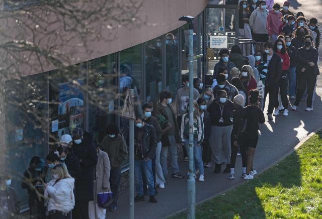 Students wearing face masks queue up to get vaccinated at the University of Kent in Canterbury, south-east England on March 18, 2026, following an outbreak of meningitis. Hundreds of masked-up students queued on March 18 to get vaccinated at the UK university campus at the heart of a deadly meningitis outbreak, as the number of cases rose to 20. (Photo by CARLOS JASSO / AFP)