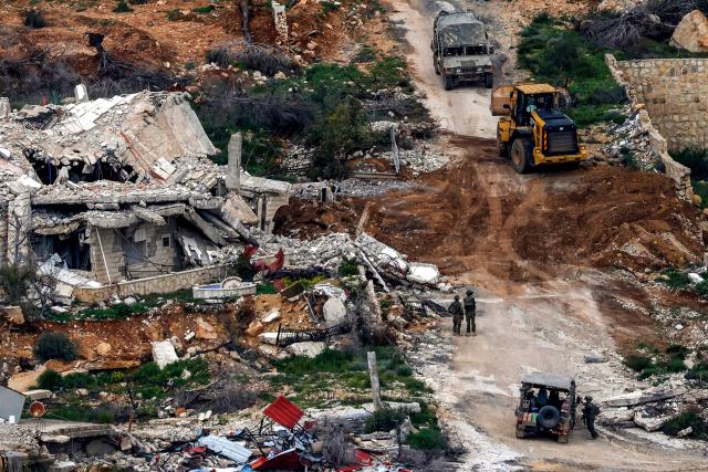 TOPSHOT - Israeli soldiers conduct an operation in a southern Lebanese village along the border, as seen from the Upper Galilee in northern Israel on March 18, 2026. The Israeli military said it planned to strike bridges and crossings over the Litani River in southern Lebanon on March 18 to disrupt what it said were Hezbollah arms-smuggling routes. Lebanon was drawn into the Middle East war on March 2 when militant group Hezbollah launched rockets into Israel to avenge the killing of Iran's supreme leader. (Photo by Jalaa MAREY / AFP) / 