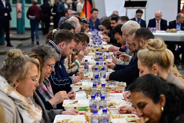 People attend the fast-breaking iftar meal organised by Berlin's Turkish Community at the end of the month of Ramadan in Berlin on March 18, 2026. (Photo by John MACDOUGALL / AFP)